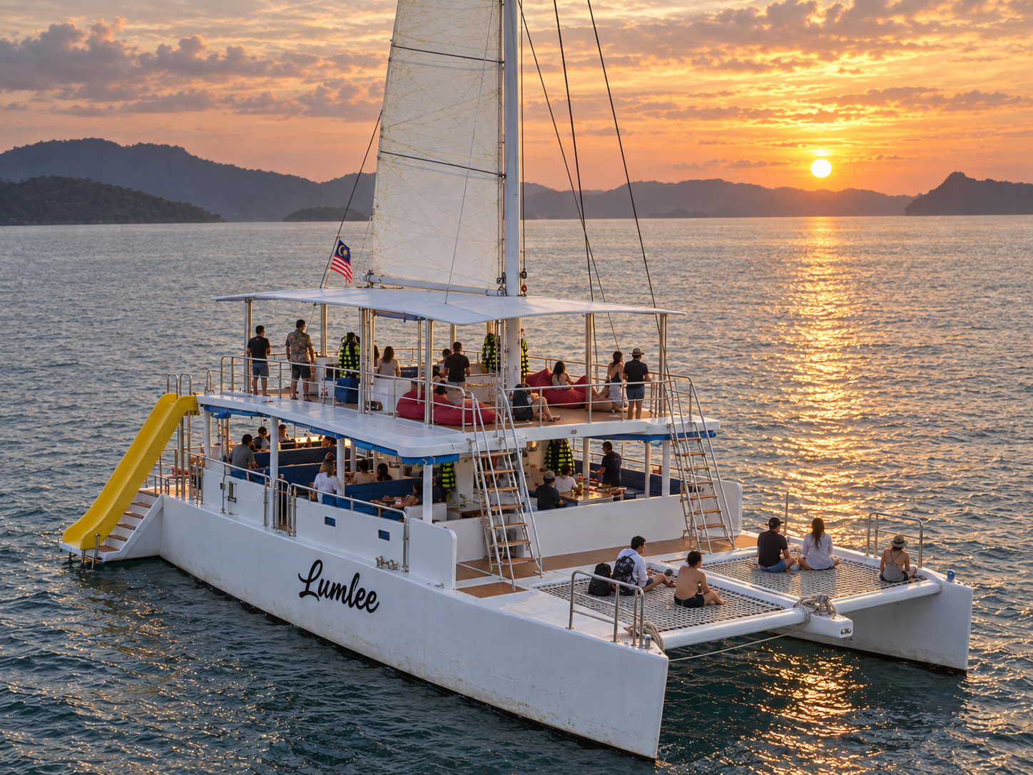 Lumlee open-air catamaran with a slide sailing at sunset in Langkawi